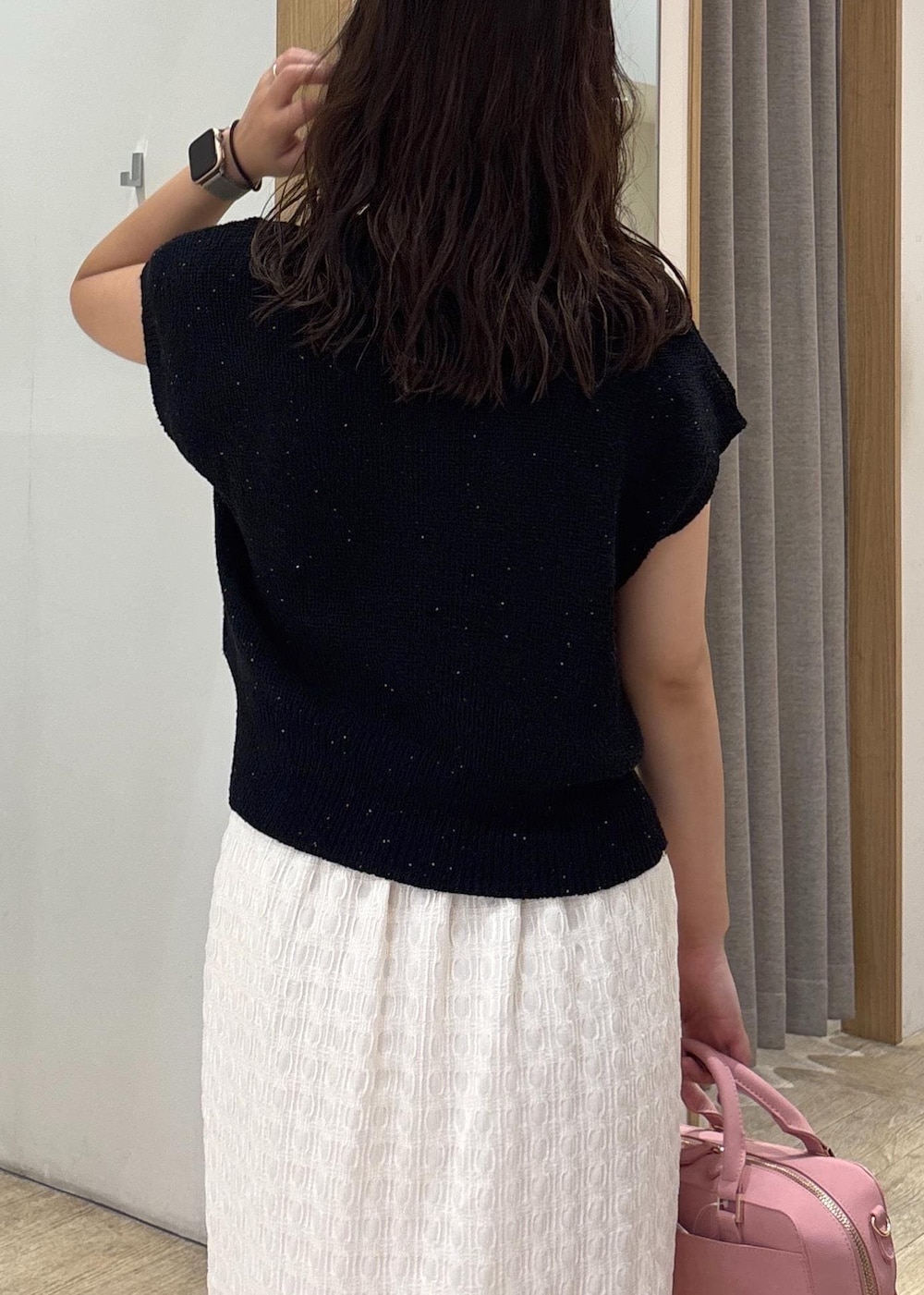 ホワイト系のスカート、ブラック系のカーディガン/ボレロ、ブラック系のパンプスを着用したレディースの夏コーディネートの7枚目の写真