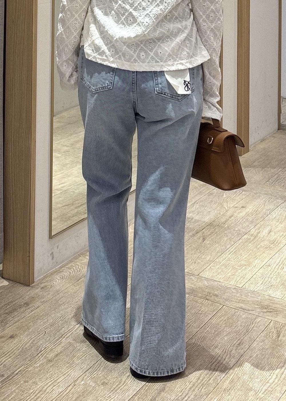 イエロー系のショルダーバッグ、ホワイト系のカーディガン/ボレロ、ブルー系のデニムパンツを着用したレディースの春コーディネートの10枚目の写真