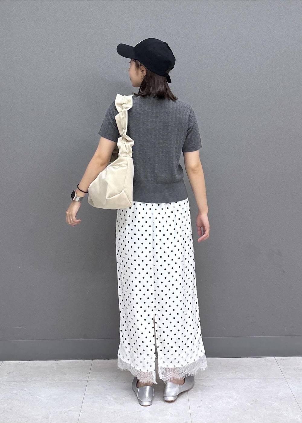 グレー系のカーディガン/ボレロ、シルバー系のパンプス、ホワイト系のスカートを着用したレディースの夏コーディネートの3枚目の写真