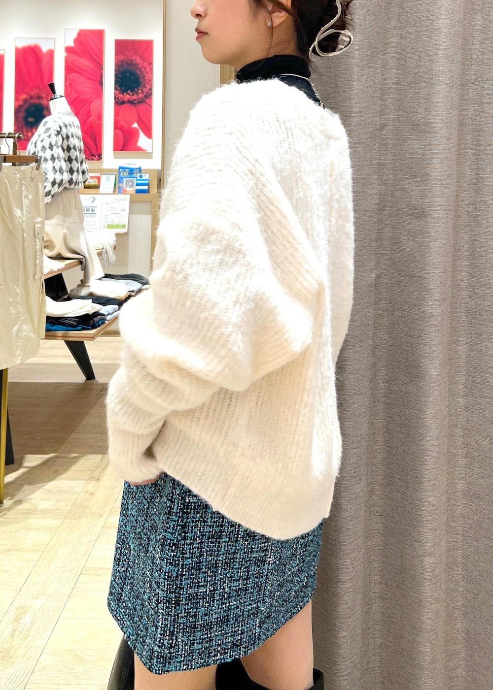 ブラック系のブーツ、ブルー系のスカート、ホワイト系のカーディガン/ボレロを着用したレディースの冬コーディネートの7枚目の写真