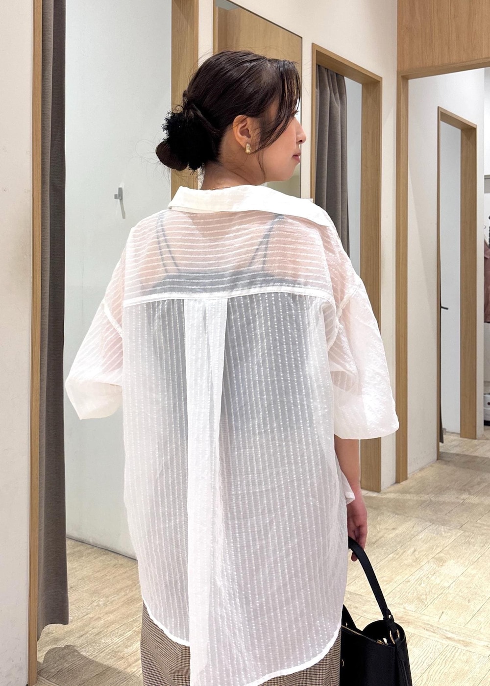 ブラック系のショルダーバッグ、ブラック系のパンプス、ホワイト系のシャツ/ブラウスを着用したレディースの秋コーディネートの6枚目の写真