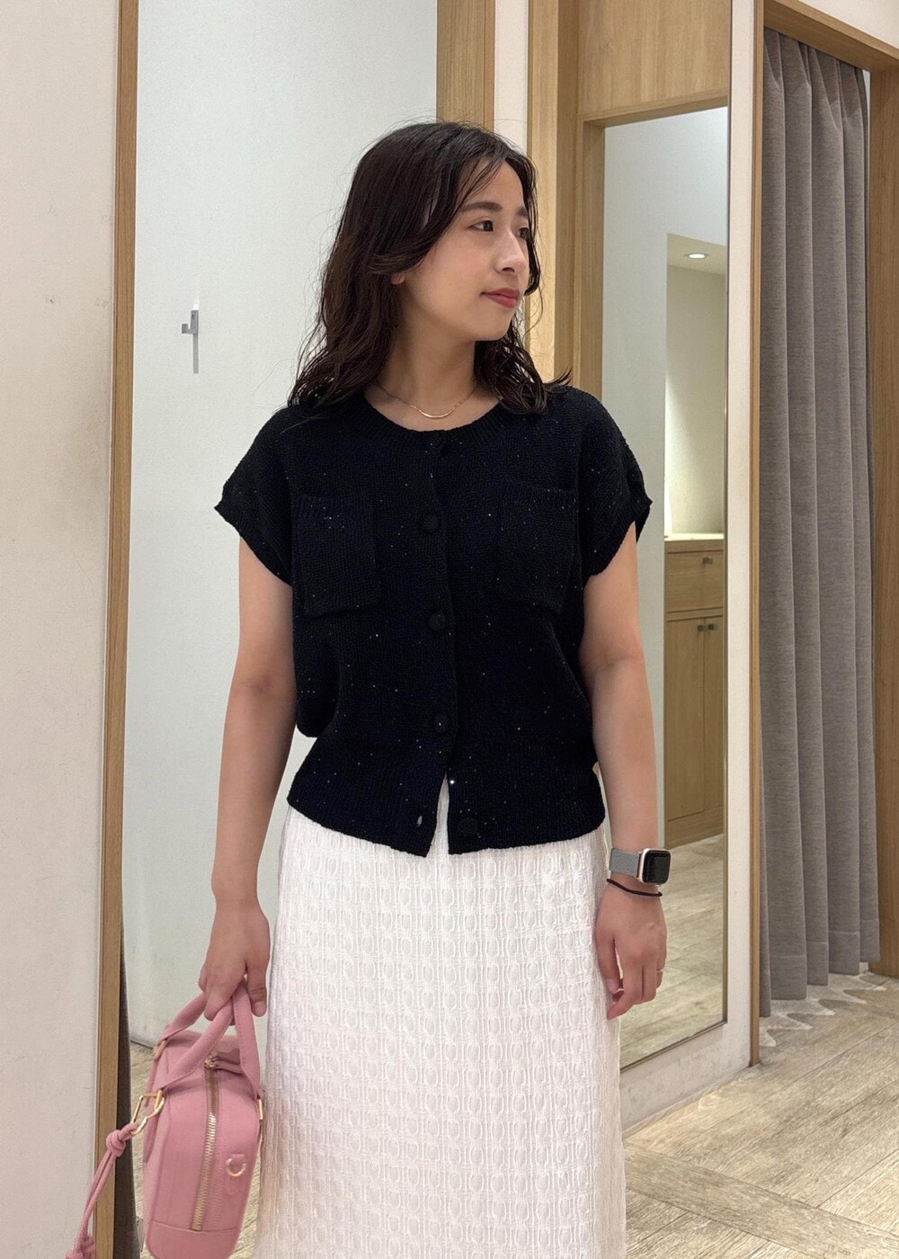 ホワイト系のスカート、ブラック系のカーディガン/ボレロ、ブラック系のパンプスを着用したレディースの夏コーディネートの5枚目の写真