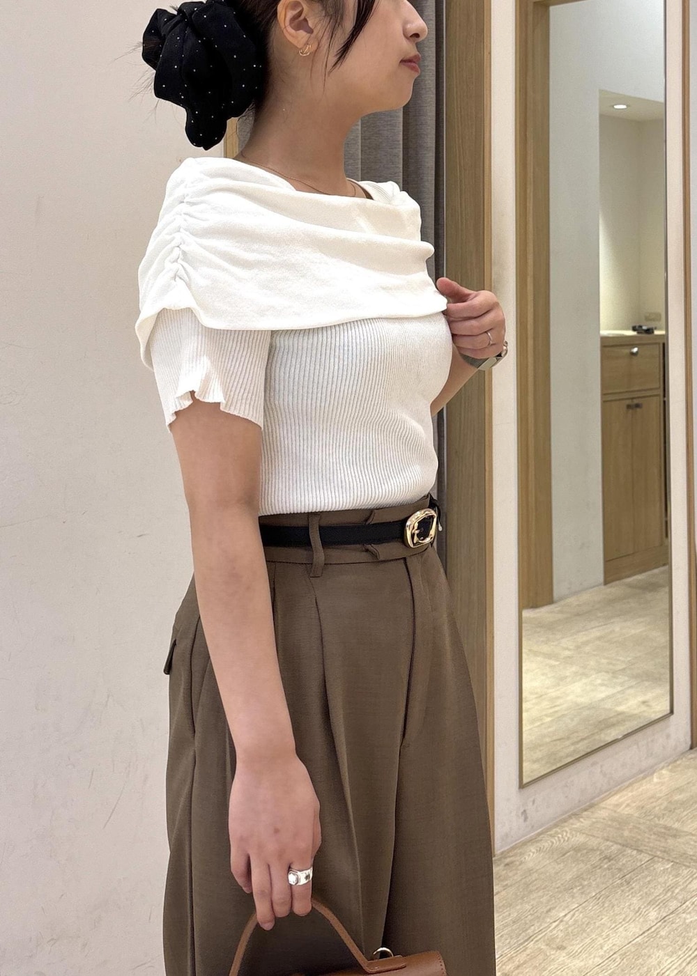 イエロー系のショルダーバッグ、ブラック系のサンダル、グリーン系のその他パンツを着用したレディースの春コーディネートの6枚目の写真
