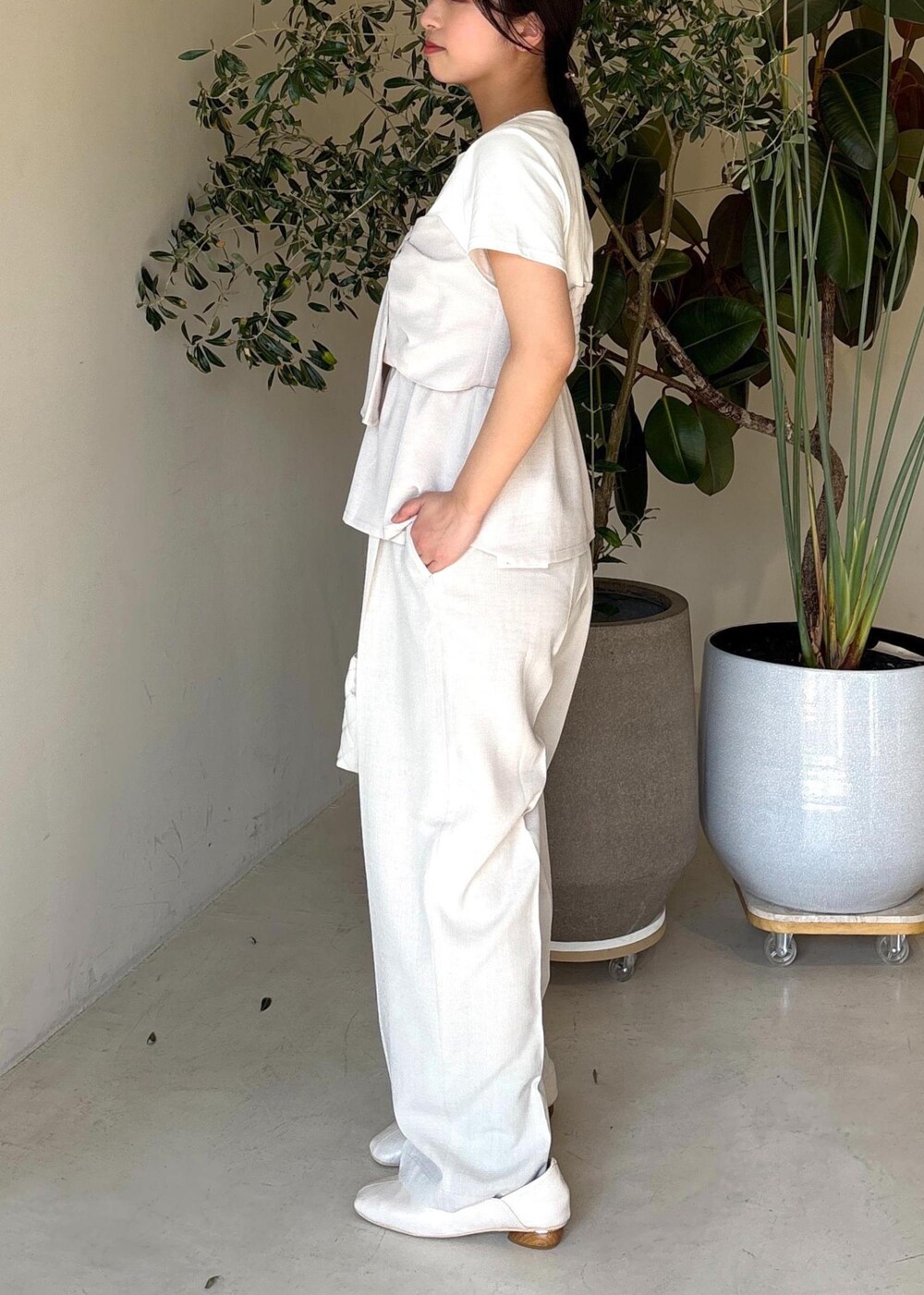 ホワイト系のパンプス、ホワイト系のTシャツ/カットソー、ホワイト系のスラックスを着用したレディースの春コーディネートの3枚目の写真