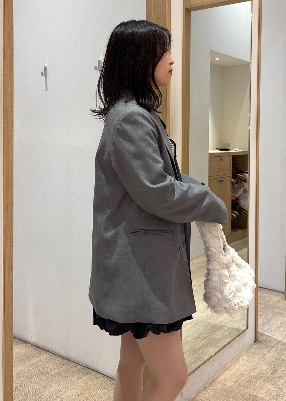 グレー系のテーラードジャケット、ブラック系のローファー、ブラック系のスカートを着用したレディースの春コーディネートの7枚目の写真