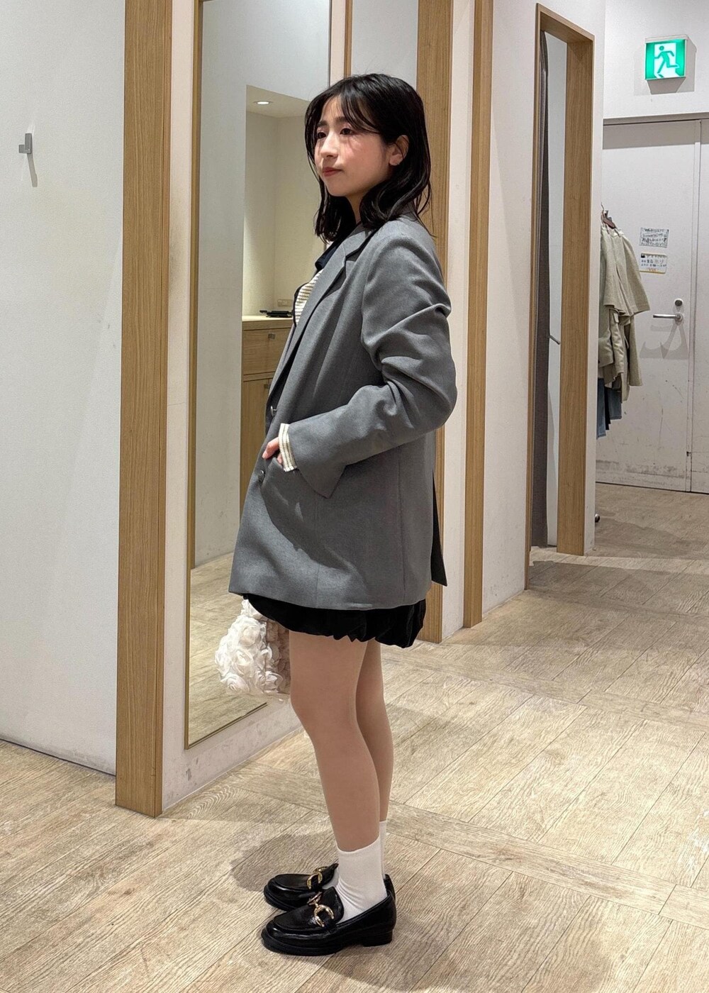 グレー系のテーラードジャケット、ブラック系のローファー、ブラック系のスカートを着用したレディースの春コーディネートの3枚目の写真