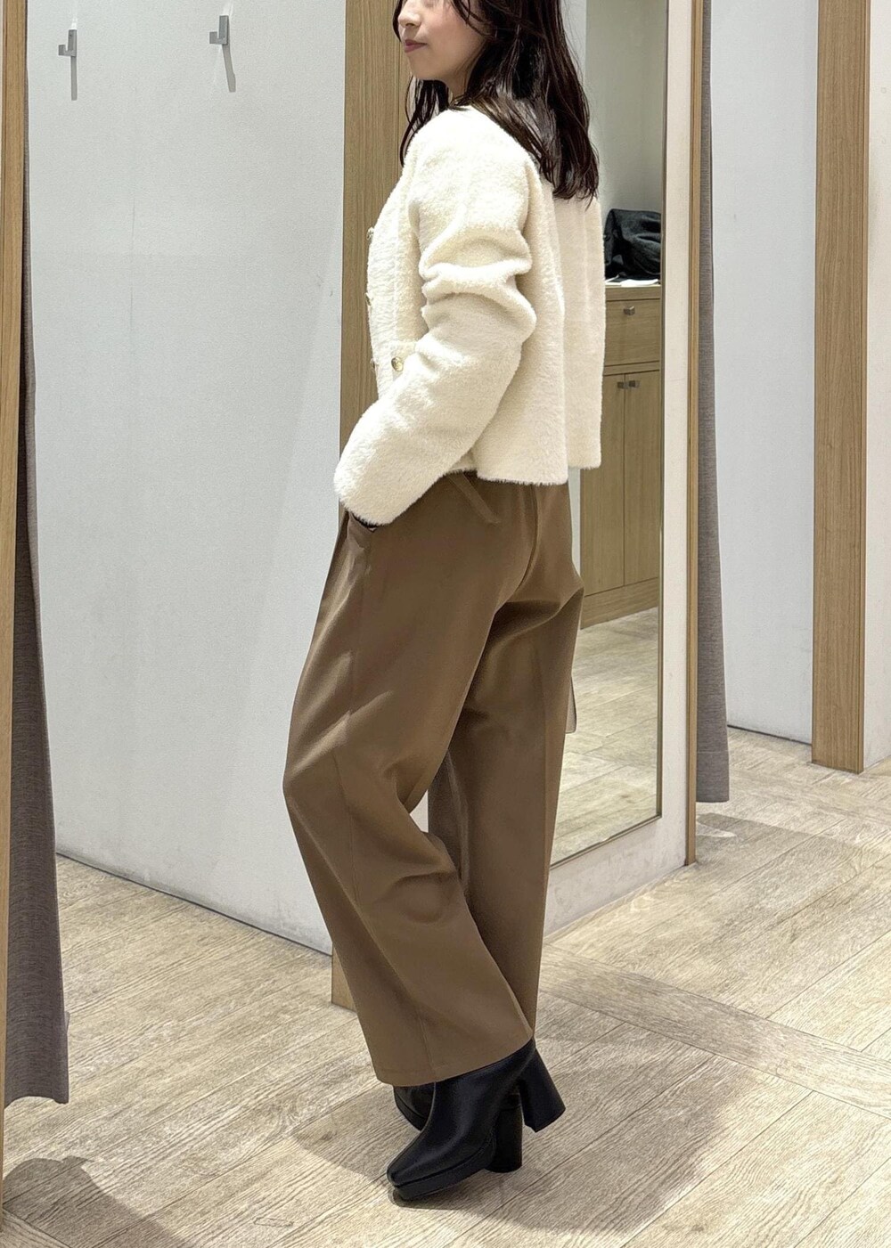 ホワイト系のカーディガン/ボレロ、ブラック系のTシャツ/カットソー、ブラック系のブーツを着用したレディースの秋コーディネートの4枚目の写真