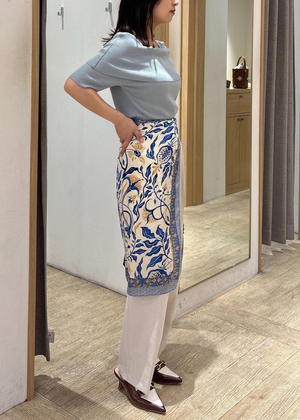 ブラウン系のパンプス、グリーン系のニット/セーター、ホワイト系のスラックスを着用したレディースの夏コーディネートの5枚目の写真