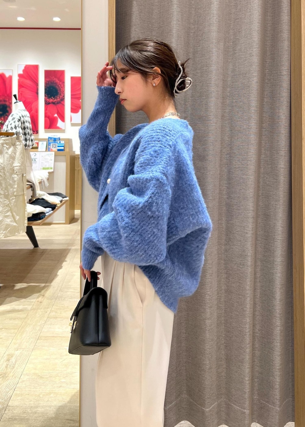 ブラック系のパンプス、ブラック系のショルダーバッグ、ブルー系のカーディガン/ボレロを着用したレディースの冬コーディネートの7枚目の写真