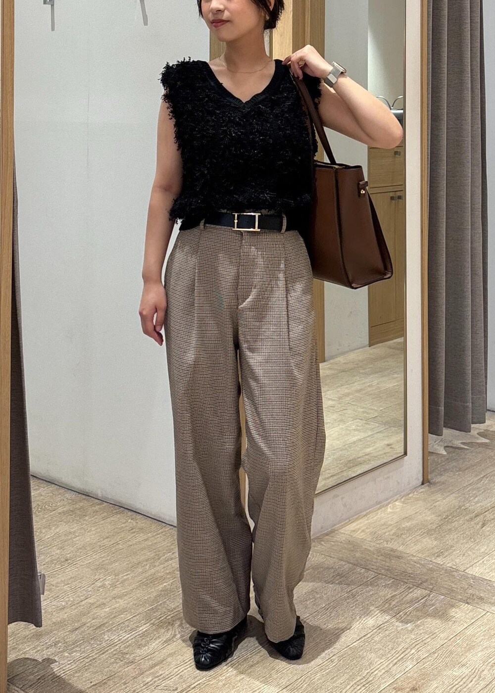 ブラック系のパンプス、ブラック系のベスト、ベージュ系のスラックスを着用したレディースの秋コーディネートの9枚目の写真