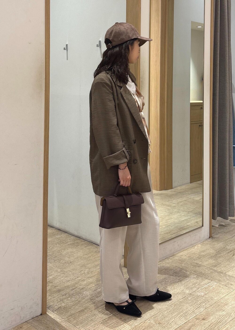 ブラウン系のショルダーバッグ、グリーン系のテーラードジャケット、ホワイト系のスラックスを着用したレディースの夏コーディネートの4枚目の写真