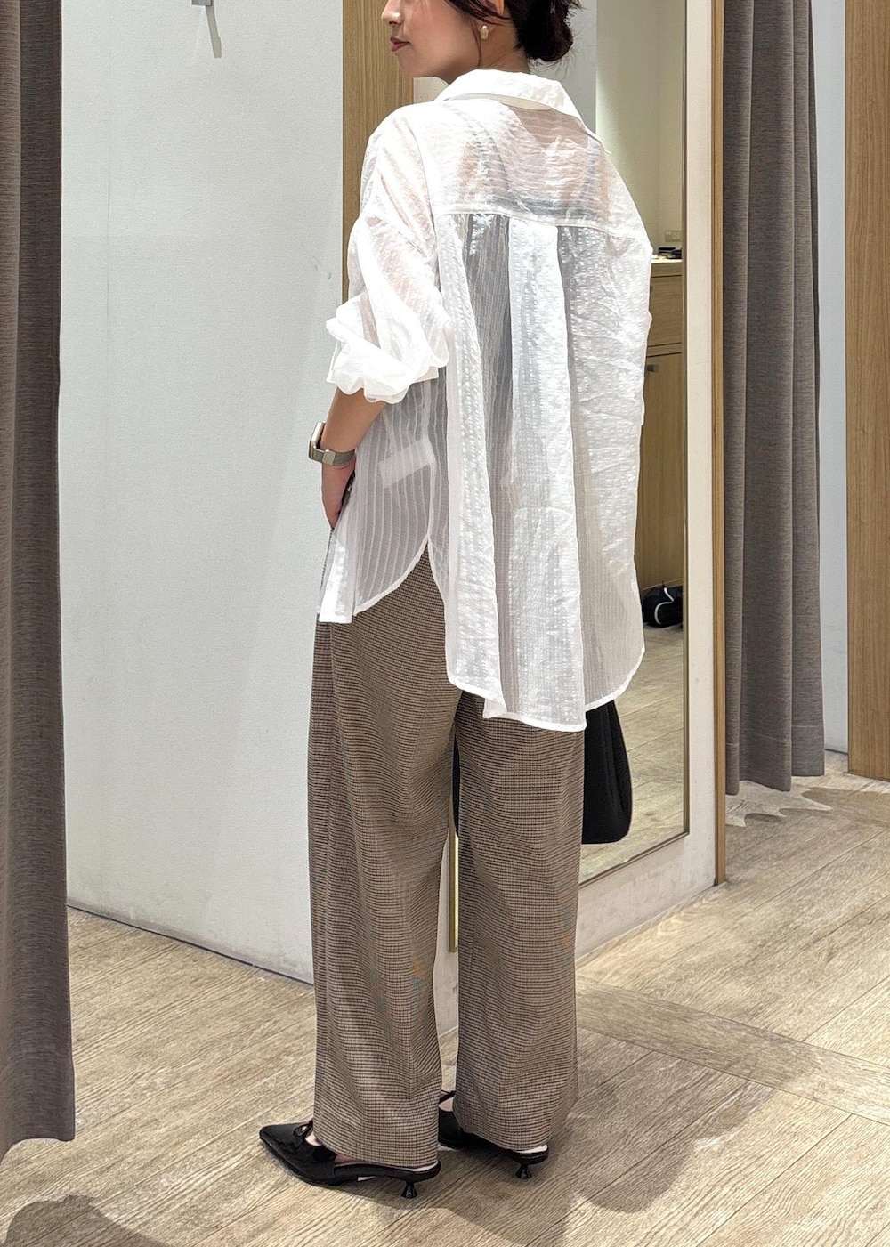 ブラック系のショルダーバッグ、ブラック系のパンプス、ホワイト系のシャツ/ブラウスを着用したレディースの秋コーディネートの3枚目の写真