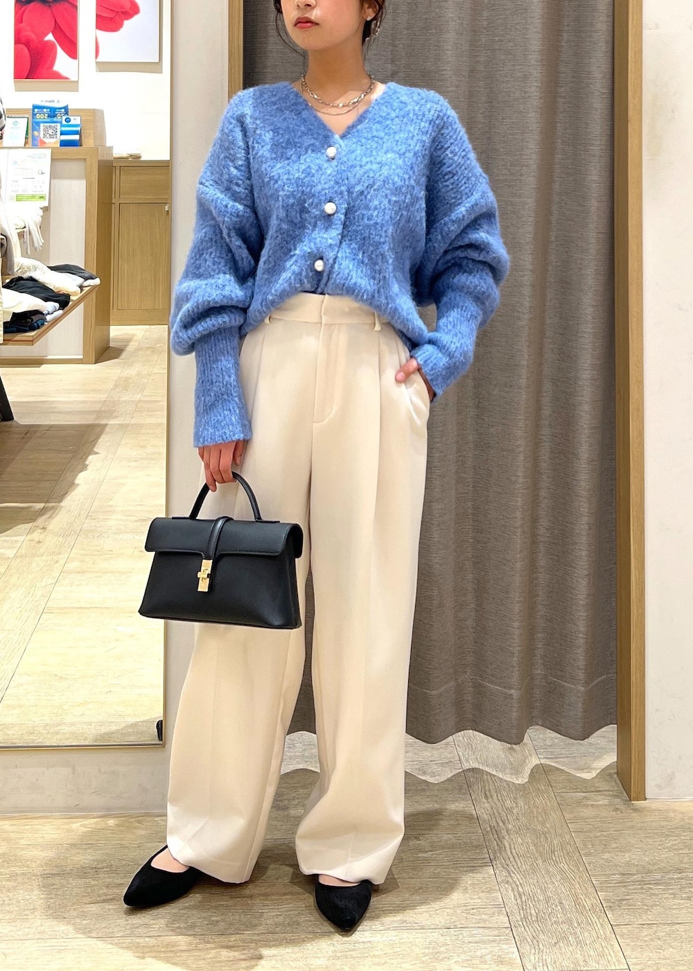 ブラック系のパンプス、ブラック系のショルダーバッグ、ブルー系のカーディガン/ボレロを着用したレディースの冬コーディネートの2枚目の写真