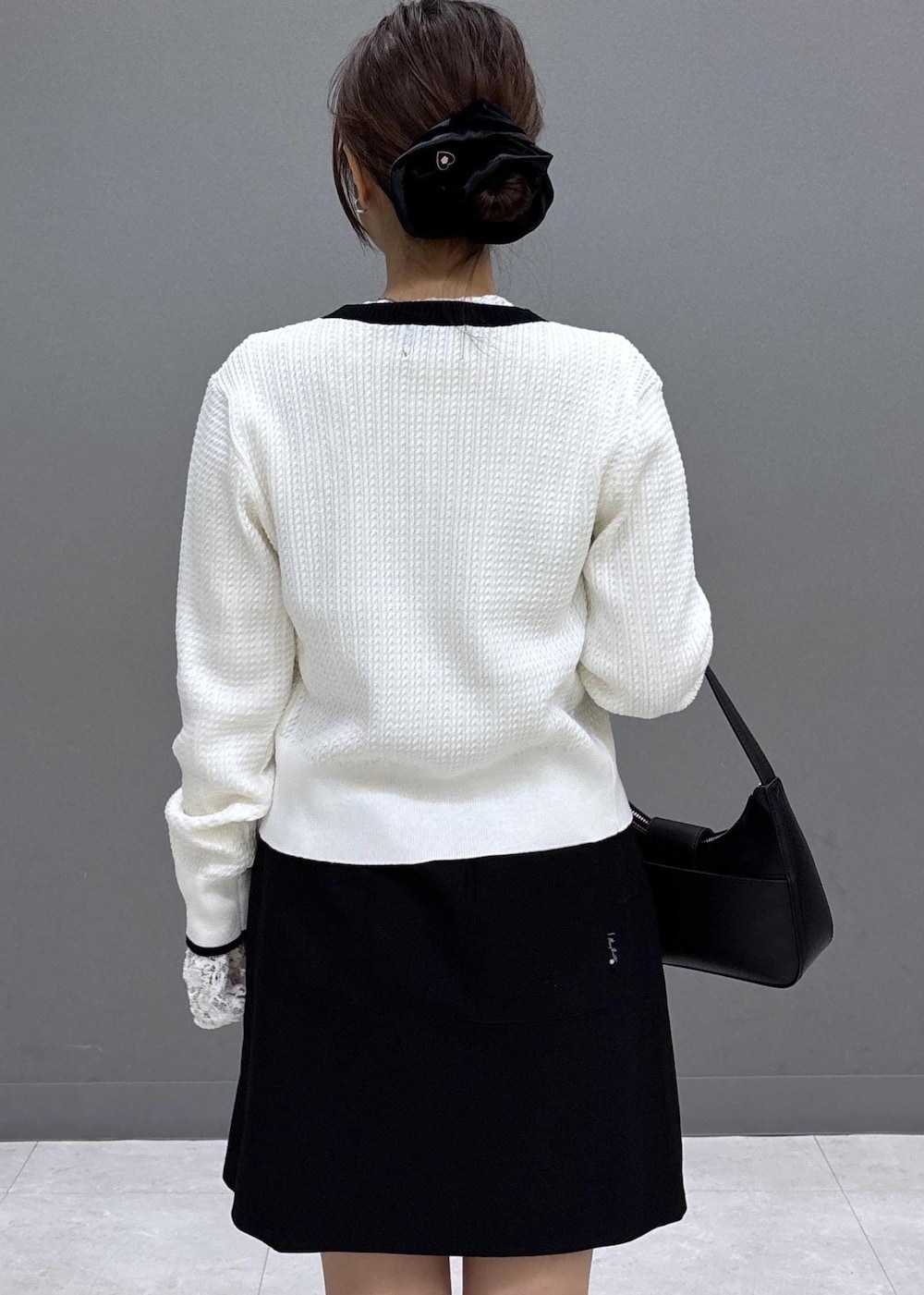 ブラック系のショルダーバッグ、ホワイト系のTシャツ/カットソー、ブラック系のブーツを着用したレディースの秋コーディネートの7枚目の写真