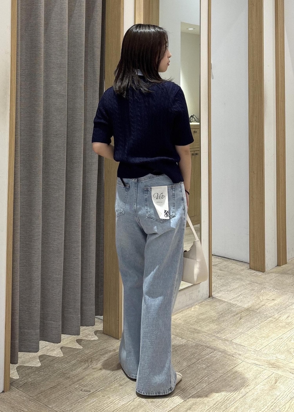ホワイト系のショルダーバッグ、ホワイト系のパンプス、ブルー系のカーディガン/ボレロを着用したレディースの春コーディネートの4枚目の写真