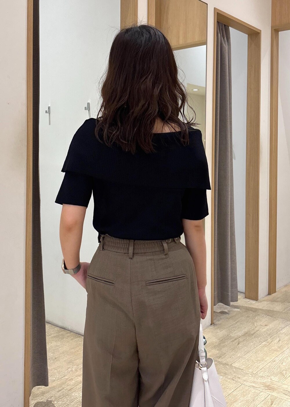 ホワイト系のショルダーバッグ、グリーン系のスラックス、ブラック系のニット/セーターを着用したレディースの夏コーディネートの7枚目の写真