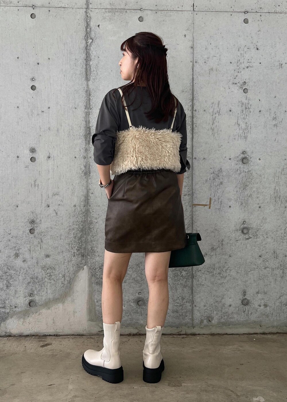 ホワイト系のブーツ、ブラウン系のスカート、ホワイト系のキャミソールを着用したレディースの秋コーディネートの4枚目の写真