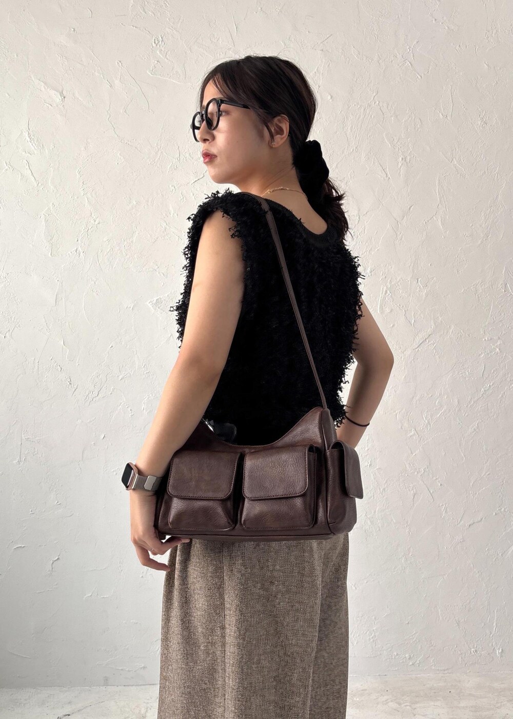 ブラック系のパンプス、ブラック系のベスト、ブラウン系のショルダーバッグを着用したレディースの夏コーディネートの6枚目の写真