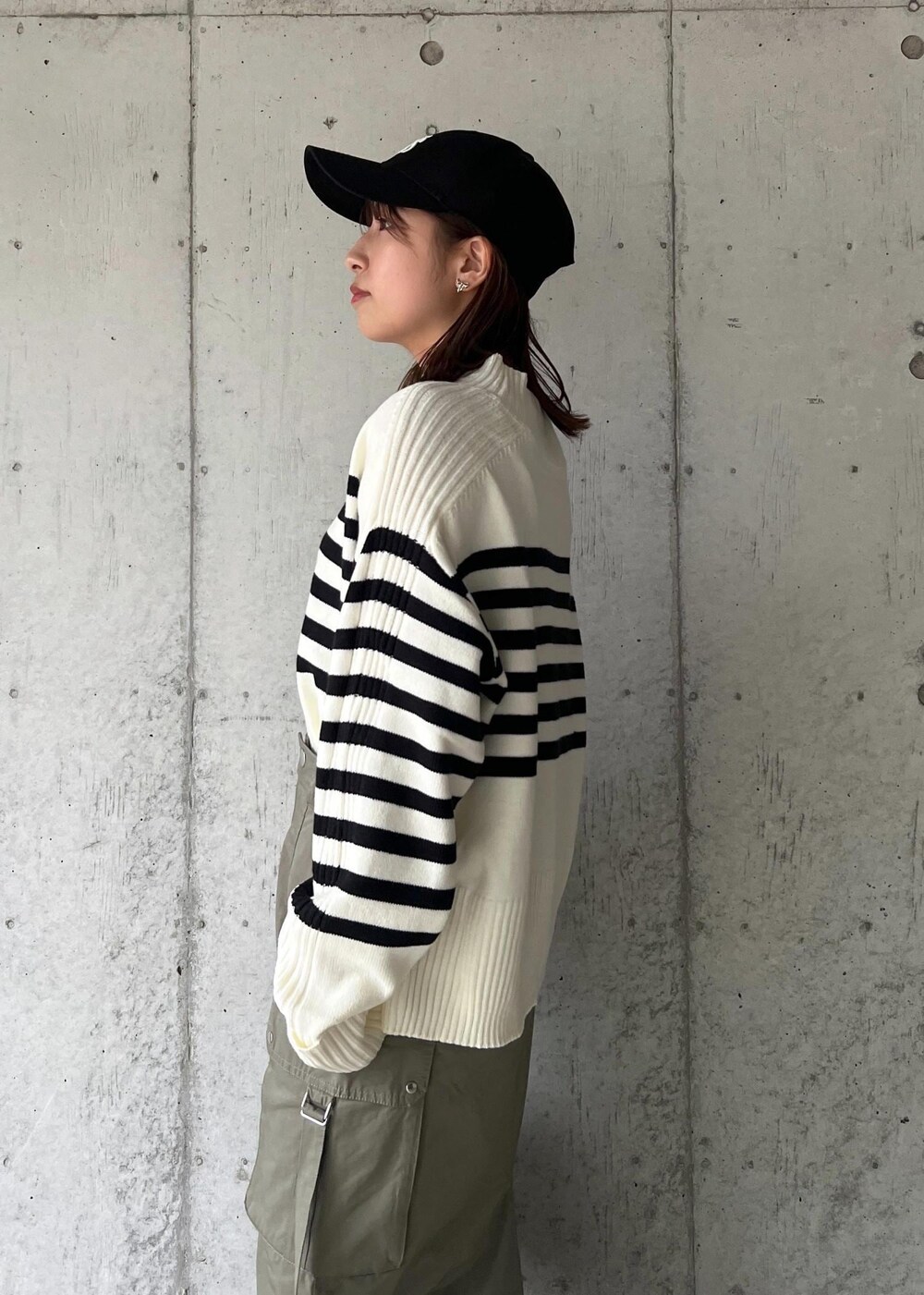 ブラック系のブーツ、グリーン系のスカート、ホワイト系のニット/セーターを着用したレディースの秋コーディネートの7枚目の写真