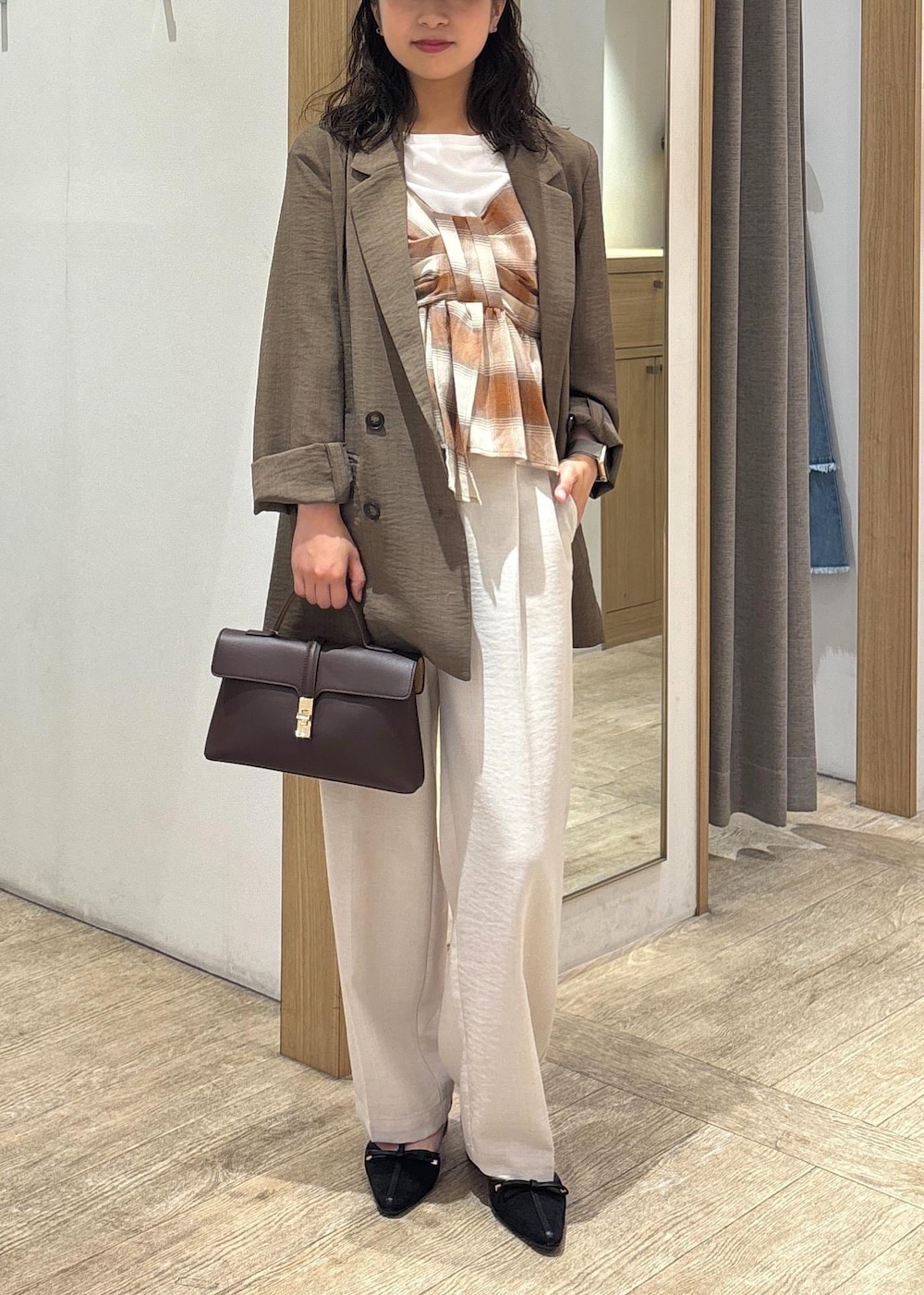 ブラウン系のショルダーバッグ、グリーン系のテーラードジャケット、ホワイト系のスラックスを着用したレディースの夏コーディネートの9枚目の写真