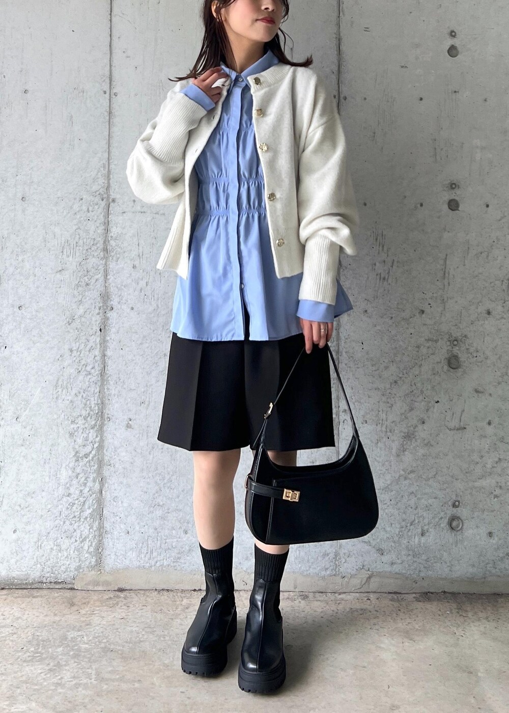 ブラック系のブーツ、ブルー系のシャツ/ブラウス、ホワイト系のカーディガン/ボレロを着用したレディースの冬コーディネートの2枚目の写真