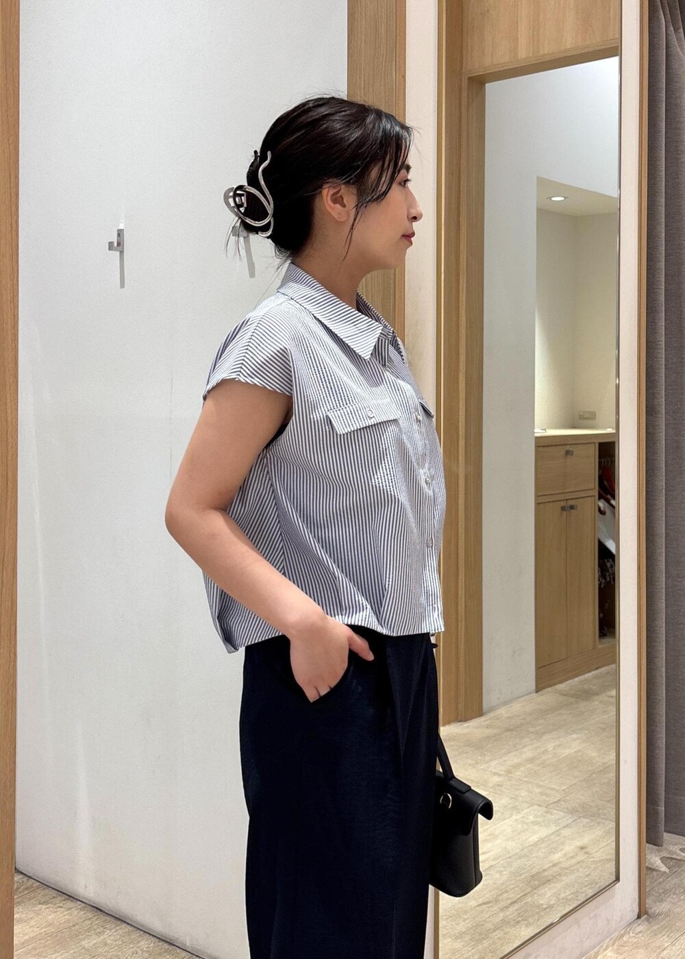 ブラック系のショルダーバッグ、シルバー系のパンプス、ブラック系のシャツ/ブラウスを着用したレディースの夏コーディネートの6枚目の写真