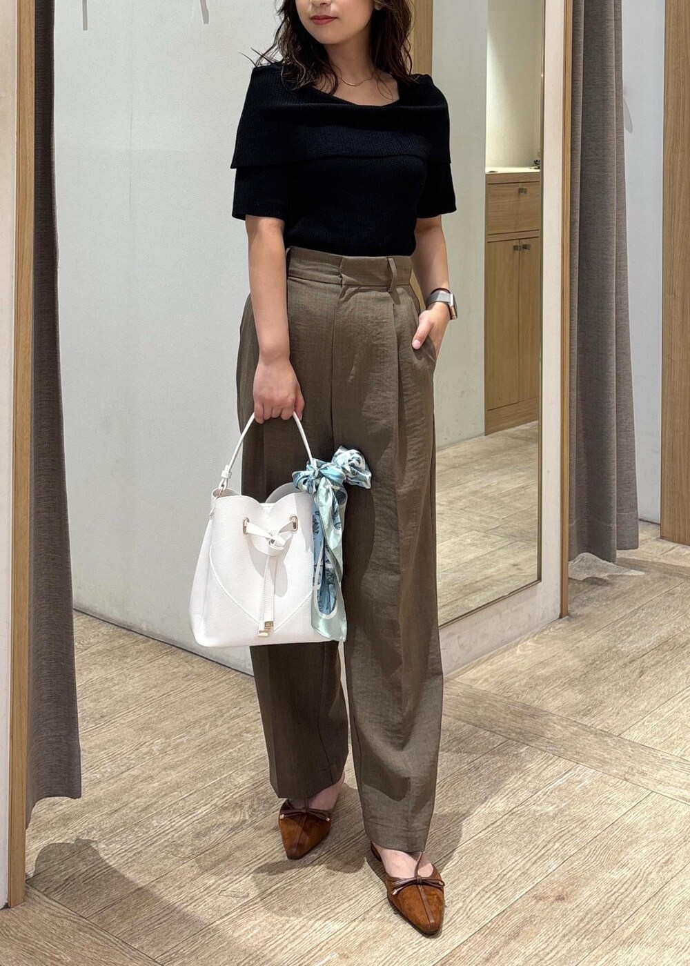 ホワイト系のショルダーバッグ、グリーン系のスラックス、ブラック系のニット/セーターを着用したレディースの夏コーディネートの10枚目の写真