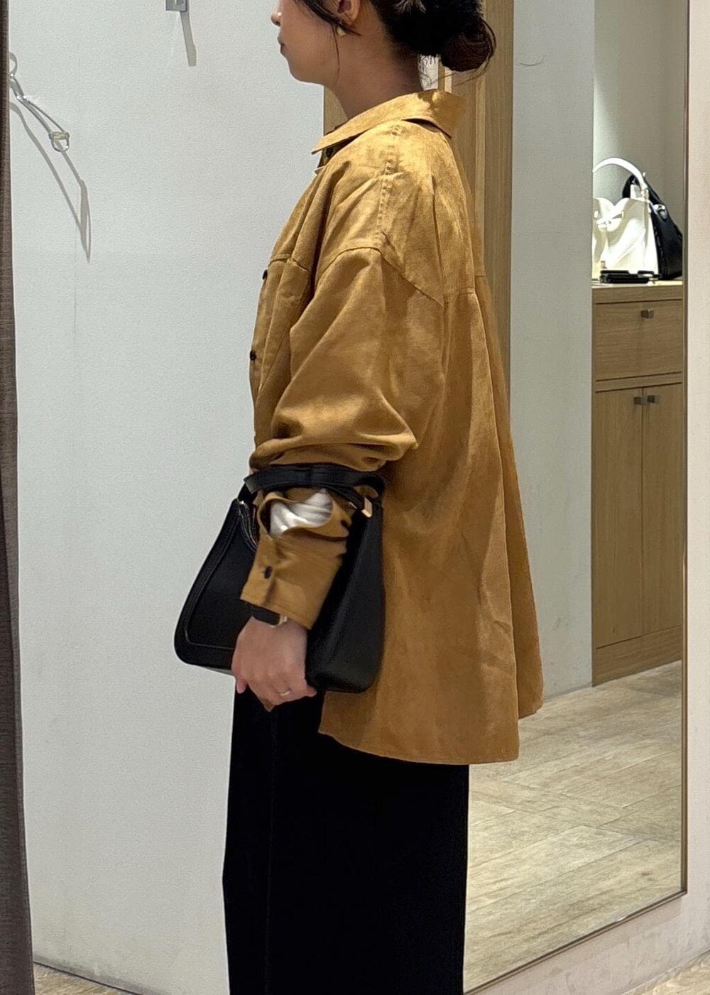 ブラック系のスカート、ブラック系のTシャツ/カットソー、ブラック系のハンドバッグを着用したレディースの秋コーディネートの6枚目の写真