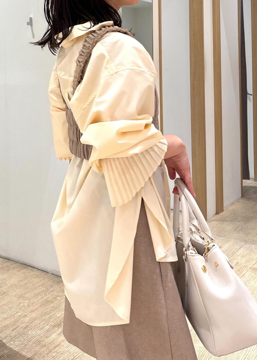 ホワイト系のショルダーバッグ、イエロー系のその他パンツ、イエロー系のベストを着用したレディースの春コーディネートの8枚目の写真