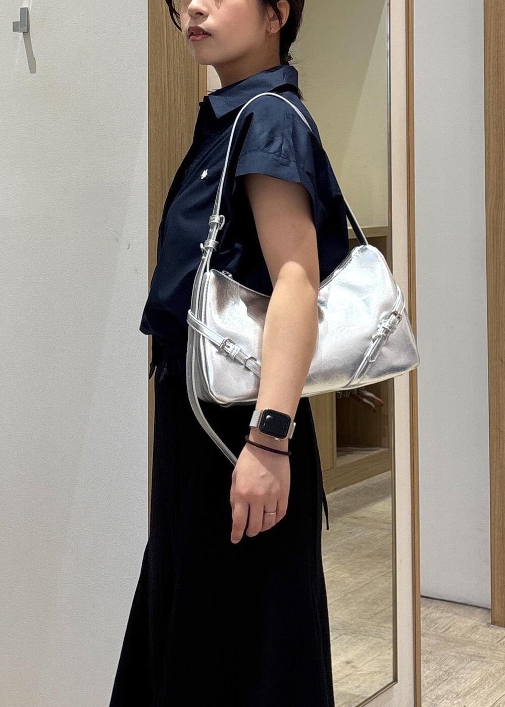 ホワイト系のキャミソール、シルバー系のパンプス、ブラック系のスカートを着用したレディースの春コーディネートの8枚目の写真