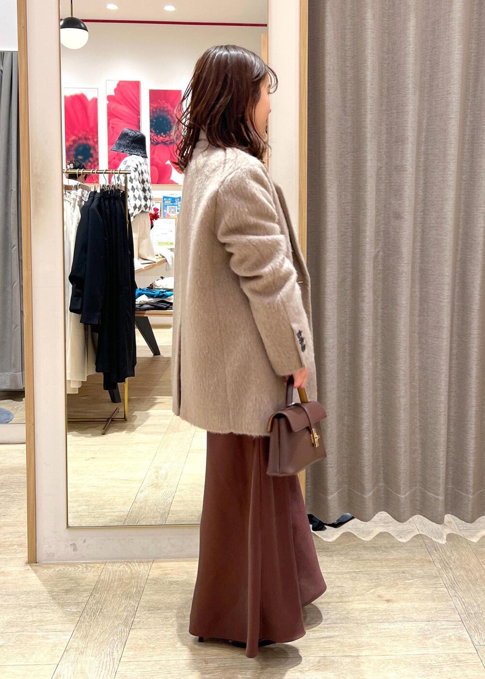 ブラック系のパンプス、ブラウン系のスカート、ホワイト系のニット/セーターを着用したレディースの冬コーディネートの4枚目の写真