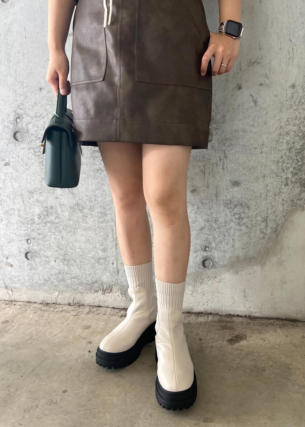 ホワイト系のブーツ、ブラウン系のスカート、ホワイト系のキャミソールを着用したレディースの秋コーディネートの8枚目の写真