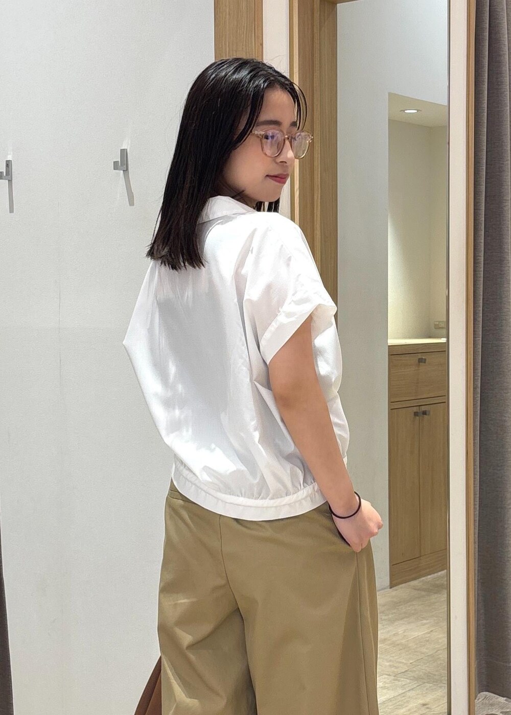 ブラウン系のショルダーバッグ、レッド系のサンダル、ホワイト系のシャツ/ブラウスを着用したレディースの夏コーディネートの6枚目の写真