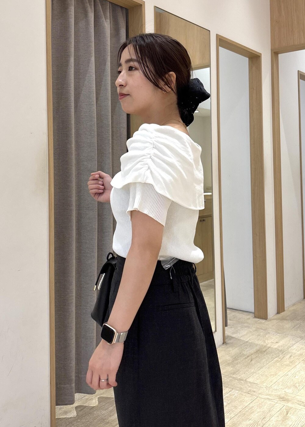 ブラック系のパンプス、ブラック系のハンドバッグ、ホワイト系のニット/セーターを着用したレディースの春コーディネートの7枚目の写真