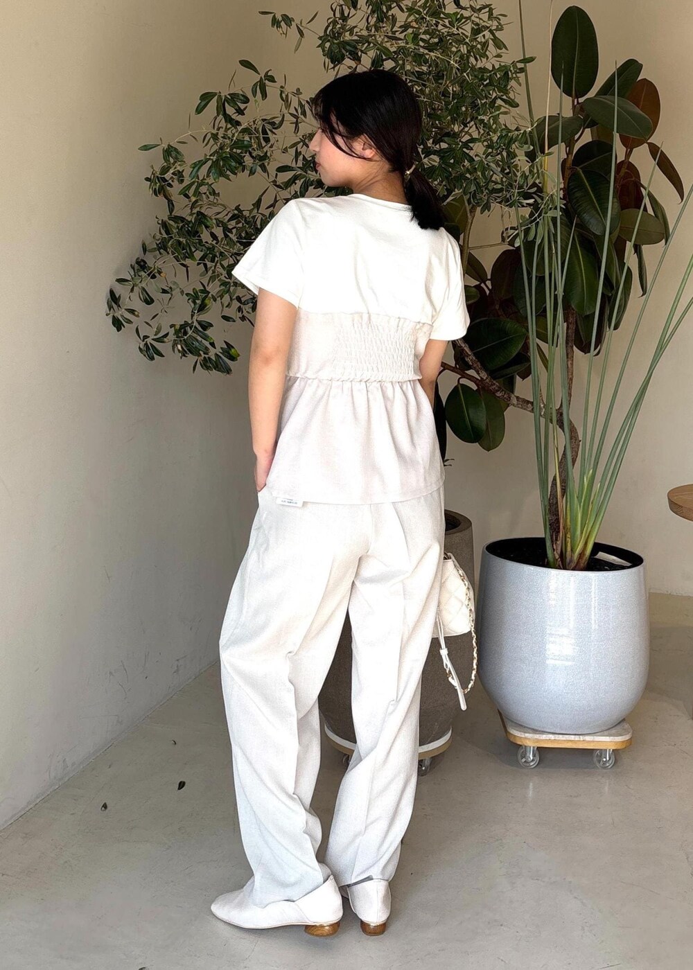 ホワイト系のパンプス、ホワイト系のTシャツ/カットソー、ホワイト系のスラックスを着用したレディースの春コーディネートの4枚目の写真