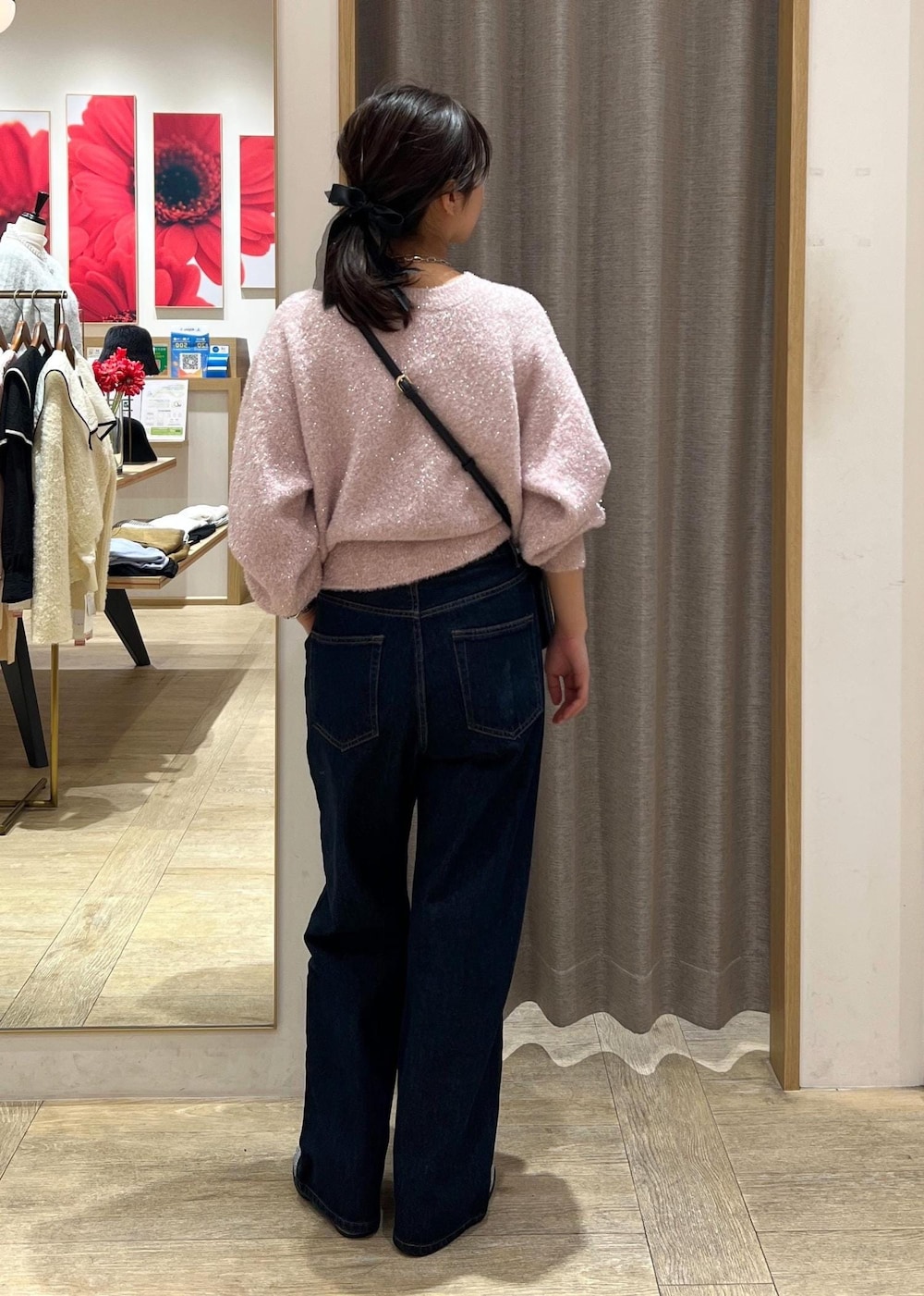 ブラック系のショルダーバッグ、シルバー系のブーツ、ブルー系のデニムパンツを着用したレディースの冬コーディネートの4枚目の写真