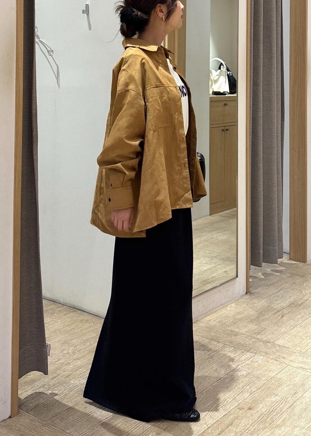 ブラック系のパンプス、ブラック系のスカート、イエロー系のシャツ/ブラウスを着用したレディースの秋コーディネートの2枚目の写真