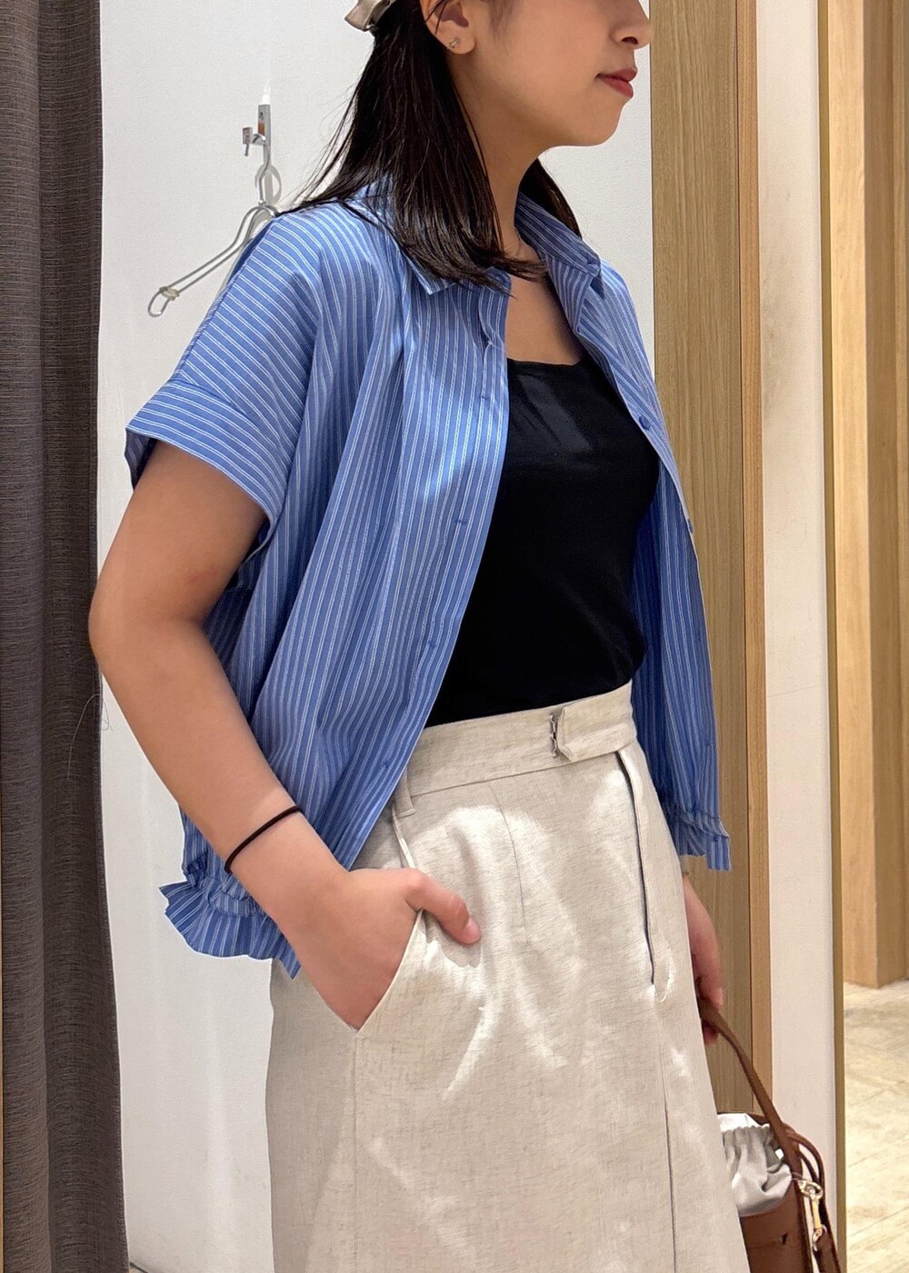 ブラック系のサンダル、ホワイト系のスカート、ブルー系のシャツ/ブラウスを着用したレディースの夏コーディネートの6枚目の写真