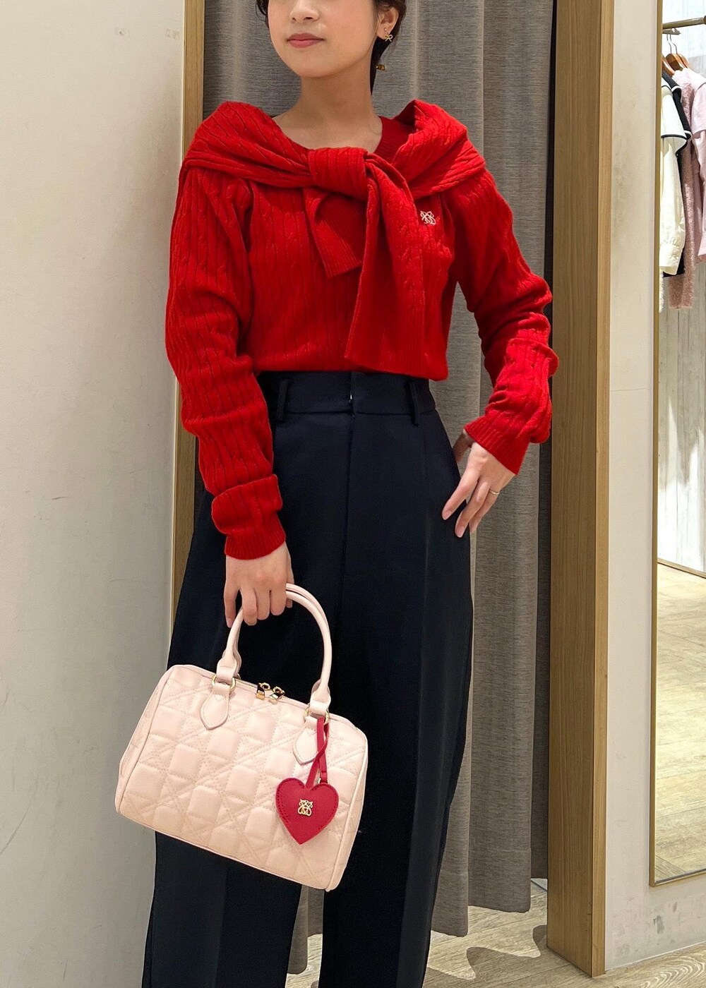 シルバー系のパンプス、レッド系のカーディガン/ボレロ、レッド系のニット/セーターを着用したレディースの冬コーディネートの8枚目の写真