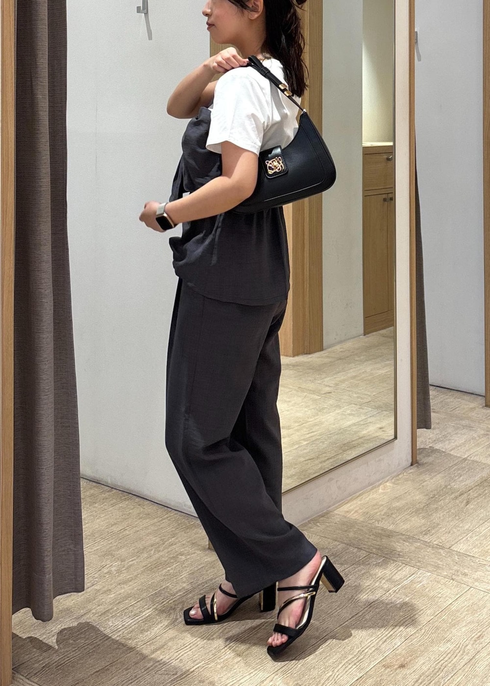 ブラック系のサンダル、グレー系のTシャツ/カットソー、グレー系のスラックスを着用したレディースの夏コーディネートの3枚目の写真