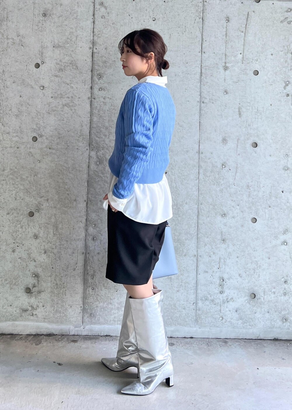 シルバー系のブーツ、ホワイト系のシャツ/ブラウス、ブルー系のニット/セーターを着用したレディースの冬コーディネートの2枚目の写真