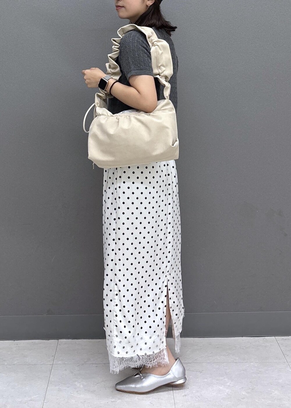 グレー系のカーディガン/ボレロ、シルバー系のパンプス、ホワイト系のスカートを着用したレディースの夏コーディネートの2枚目の写真