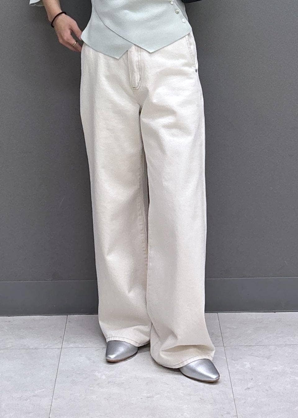 ブラック系のショルダーバッグ、シルバー系のパンプス、グリーン系のニット/セーターを着用したレディースの秋コーディネートの9枚目の写真