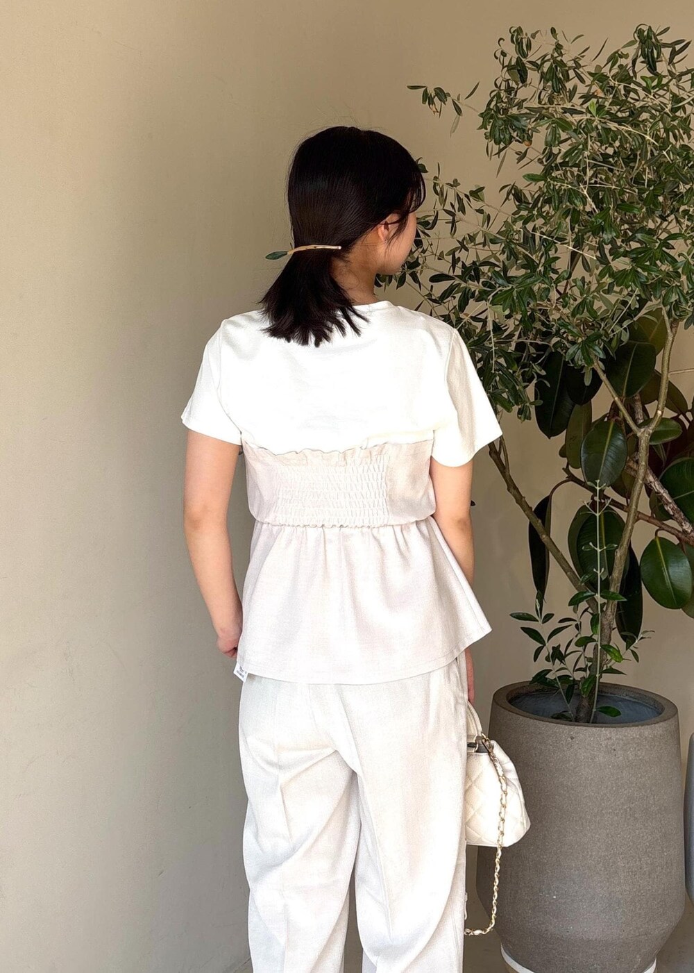 ホワイト系のパンプス、ホワイト系のTシャツ/カットソー、ホワイト系のスラックスを着用したレディースの春コーディネートの10枚目の写真