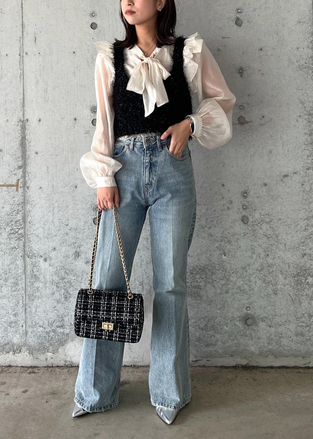 ブルー系のデニムパンツ、ブラック系のキャミソール、シルバー系のブーツを着用したレディースの秋コーディネートの2枚目の写真