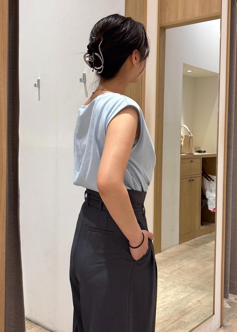 ブラック系のサンダル、ブルー系のTシャツ/カットソー、グレー系のスラックスを着用したレディースの夏コーディネートの6枚目の写真