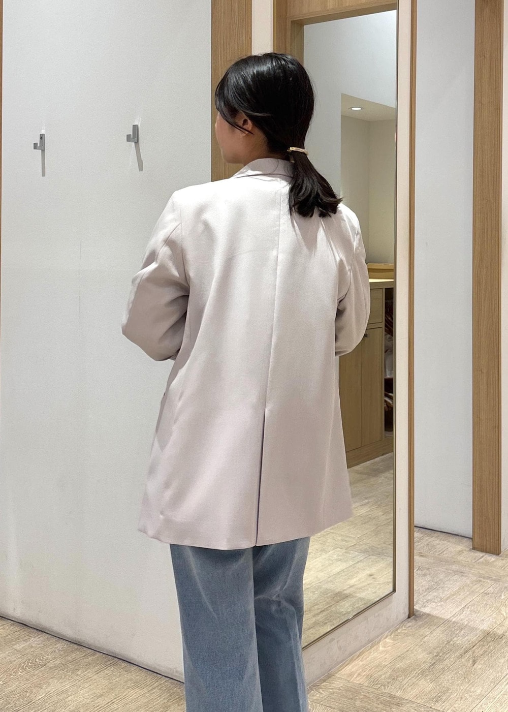 グレー系のショルダーバッグ、ベージュ系のテーラードジャケット、ブルー系のデニムパンツを着用したレディースの春コーディネートの7枚目の写真