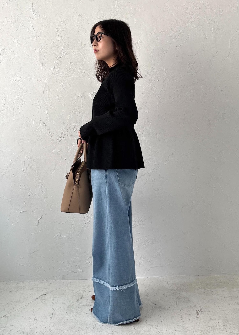 ブルー系のデニムパンツ、イエロー系のパンプス、ベージュ系のボストンバッグを着用したレディースの夏コーディネートの2枚目の写真