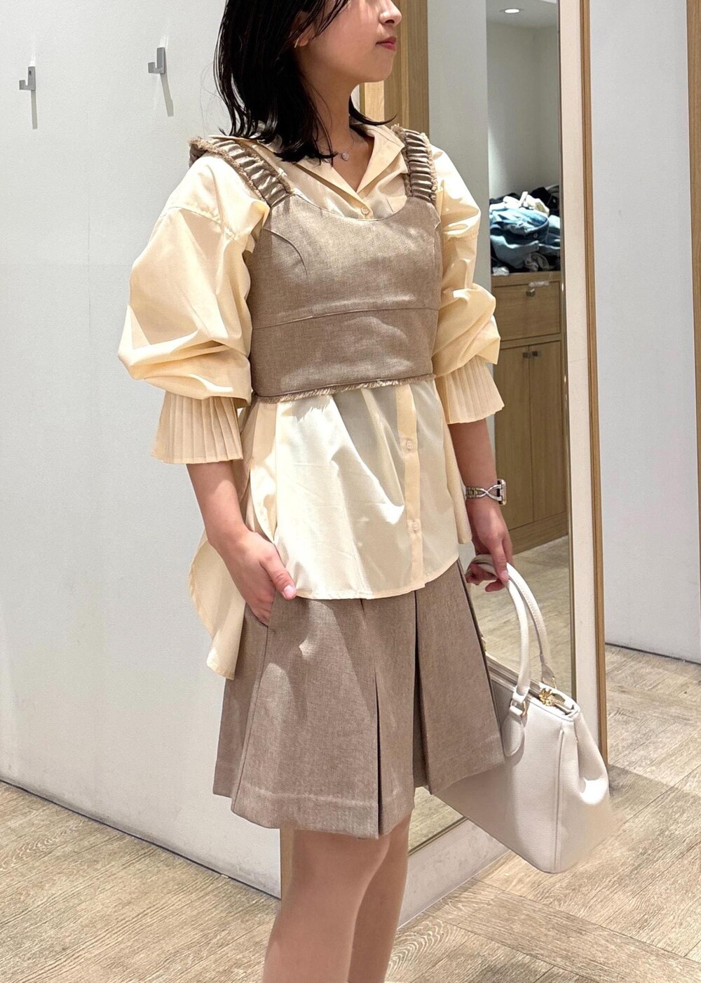 ホワイト系のショルダーバッグ、イエロー系のその他パンツ、イエロー系のベストを着用したレディースの春コーディネートの5枚目の写真