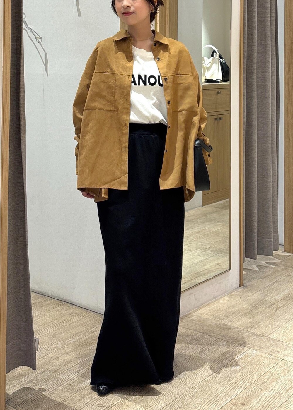 ブラック系のパンプス、ブラック系のスカート、イエロー系のシャツ/ブラウスを着用したレディースの秋コーディネートの10枚目の写真